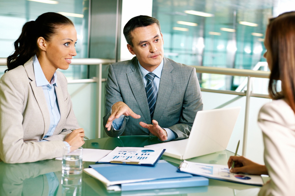 3 personnes autour d'un bureau qui discute sur l'organisation et l'optimisation commercial de leur entreprise